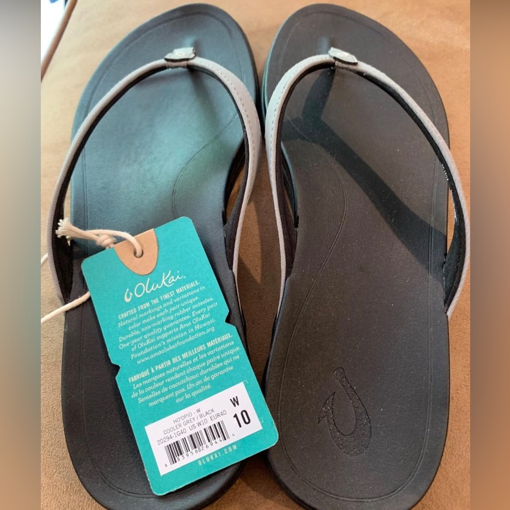 OluKai Woman’s flip flops.    Grey and Black.  Never worn